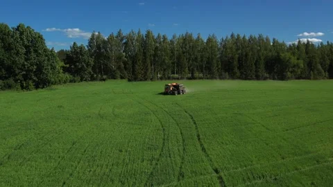 Self-propelled sprayer-spreader of orange color works on the field Stock Footage 271477925