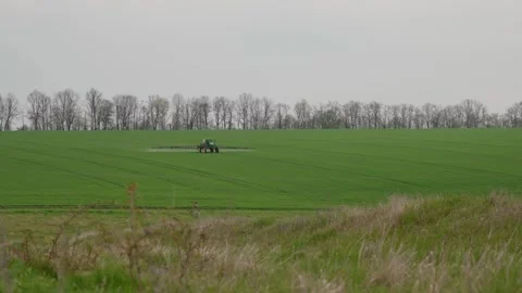 A self-propelled sprayer works in the field. Fertilizing the soil. Stock Footage 242596593