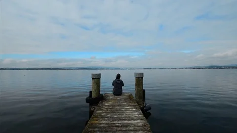 Self-reflection. Figure on the pier. Overcast over the lake. Stock Footage 82902737