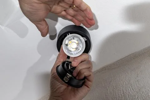 Self-replacement of a burnt-out LED bulb, black surface-mounted fixture sus.. Stock Photos