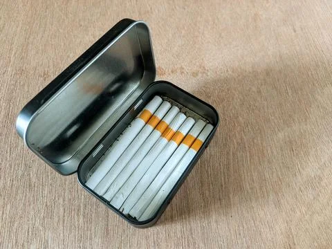 Self-rolling cigarettes in a black tin box Stock Photos