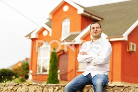 Self-satisfied man in front of his own house. Stock Photos
