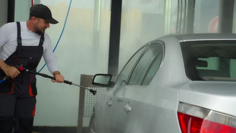 At self-service car wash, man with beard use pressure washer to clean grimy.. Stock Footage 320890563