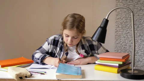 Self-study activities. Girl of middle school age is doing homework. Video stock 128368147