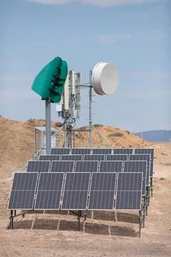 Self-sufficient cell phone tower in the desert with solar panels and a wind Stock Photos