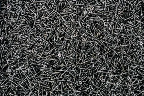 Self-tapping black screw. The screws in the box. Background of a large number Stock Photos
