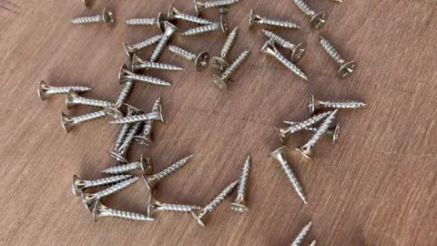 Self-Tapping Drywall Screws Placed on Plywood Surface Видео 324008759