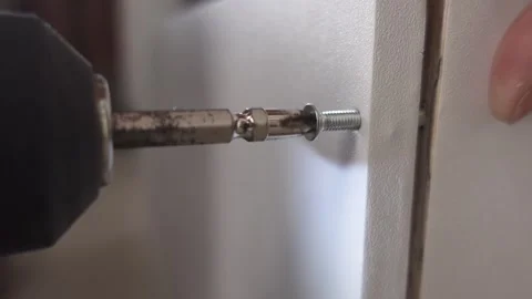 Self tapping screws with a drill tip twisted into a multiplex board Stock Footage 326063819