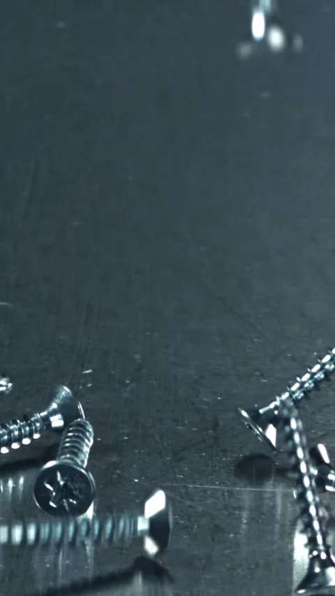 Self-tapping screws fall on a metal table. Filmed on a high-speed camera at 1000 Stock Footage 335363110