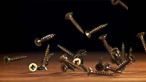 Self-tapping screws fall on a wooden table. Filmed on a high-speed camera at Stock Footage 307929019
