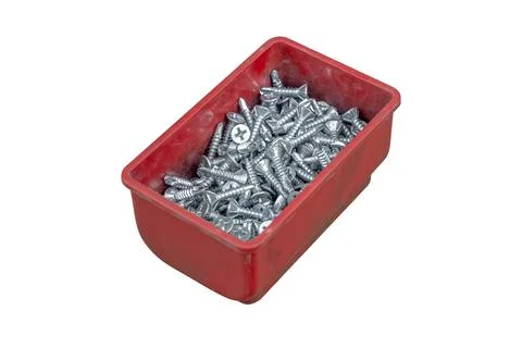 Self-tapping screws in a red plastic box, isolated on white. Foto stock