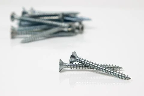Self-tapping screws on a white background. Chrome plated screws.  Stock Photos