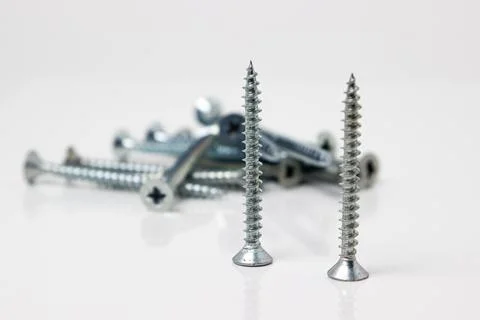 Self-tapping screws on a white background. Chrome plated screws.  Stock Photos