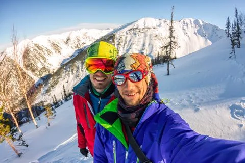 Selfie couples men skiers freeriders in snowy mountains Stock Photos