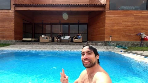 Selfie of friends waving at the camera from the pool at an outdoor country house Stock Footage 199542319