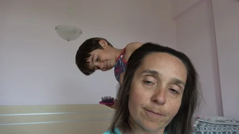 Selfie Funny son makes witch from his mother combing her Stock Footage 108394791