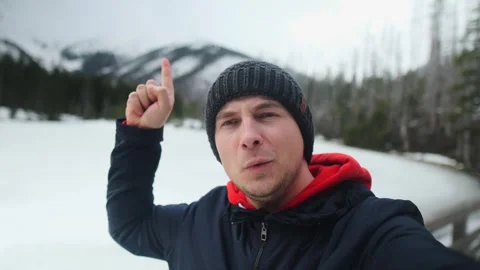 Selfie of a happy average man in the mountains showing scenery behind his back Stock Footage 247895251