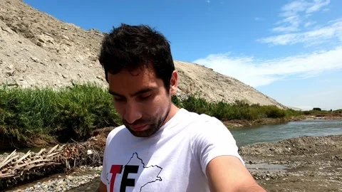 Selfie talking between farmland with the river and vegetation between hills with Stock Footage 197087466