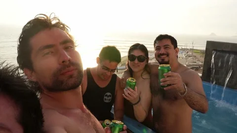 Selfie toasting with cans of beer with several friends on a terrace with a pool Stock Footage 173514461