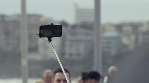 Selfies stick with smart phone in a crowd of tourists Video stock 65375514