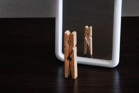 Selfish concept. small clothespin seeing himself in the mirror as big king wi Stock Photos