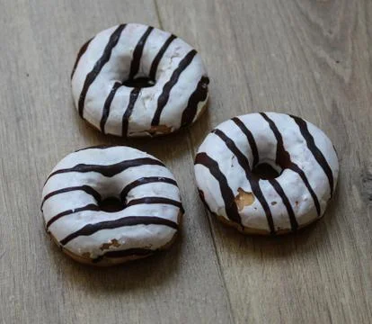 Selfmade vanilla donuts on table. The donuts have white glaze with brown choc Stock Photos