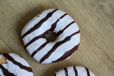 Selfmade vanilla donuts on table. The donuts have white glaze with brown choc Stock Photos