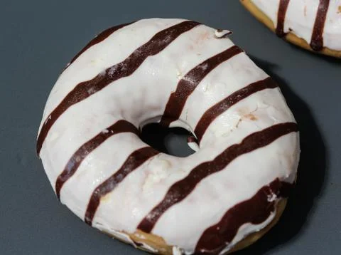 Selfmade vanilla donuts on table. The donuts have white glaze with brown choc Stock Photos