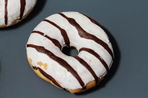 Selfmade vanilla donuts on table. The donuts have white glaze with brown choc Stock Photos