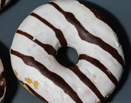 Selfmade vanilla donuts on table. The donuts have white glaze with brown choc Stock Photos