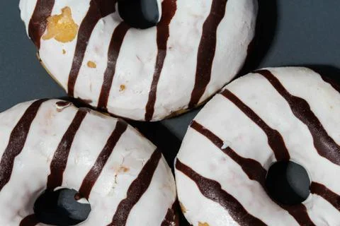 Selfmade vanilla donuts on table. The donuts have white glaze with brown choc Stock Photos