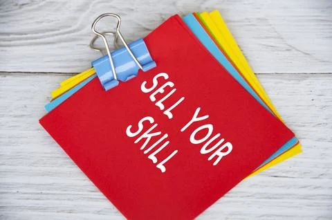 Sell your skill text on red notepad on white wooden background Stock Photos