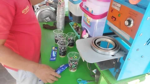 A seller is adding Oreo biscuits to a teapot ice cream Stock Footage 241709356