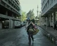 Seller carrying cleaning equipment walking past camera SD Footage