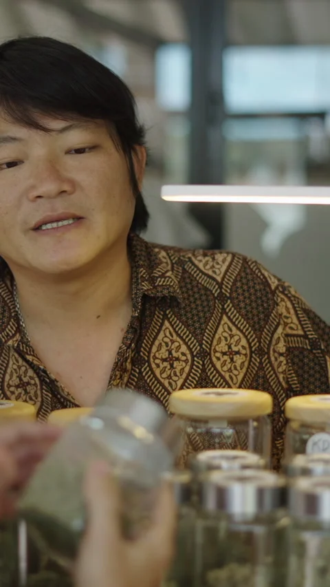 A seller explains something about a type of weed Stock-Footage 267510148