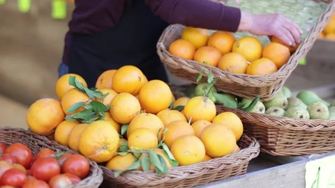 Seller hands hold selected oranges in close up. Supermarket worker checking the Stock Footage 341426843