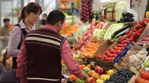 The seller helps the buyer to choose fruits and vegetables Stock Footage 59337166
