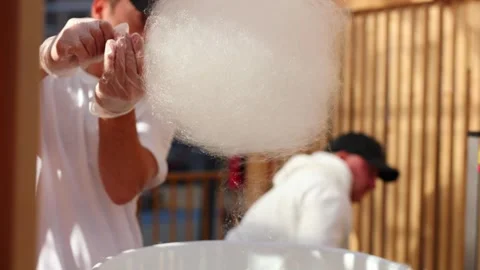 Seller makes cotton candy, a machine for making cotton candy on the street. Stock Footage 309814964
