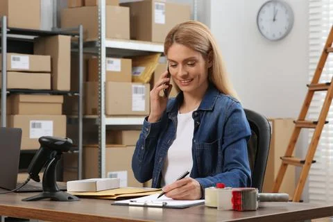 Seller talking on phone while working in office. Online store Photos