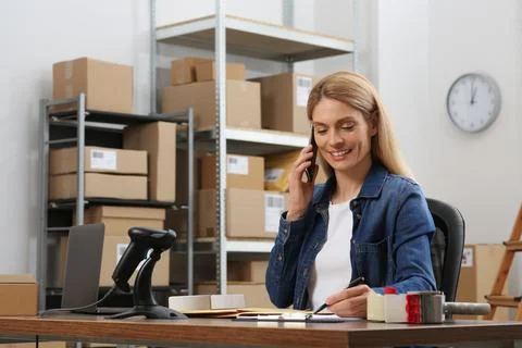 Seller talking on phone while working in office. Online store Photos