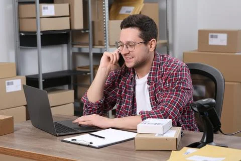 Seller talking on phone while working in office. Online store Photos