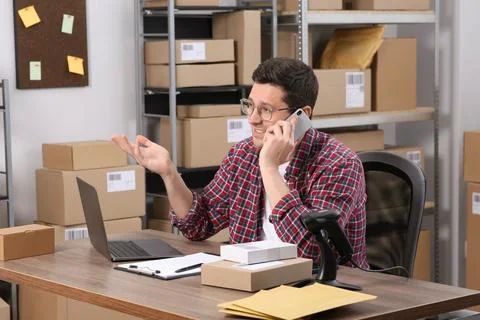 Seller talking on phone while working in office. Online store Photos