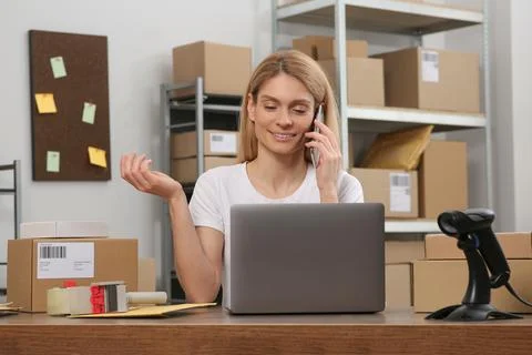 Seller talking on phone while working in office. Online store Photos