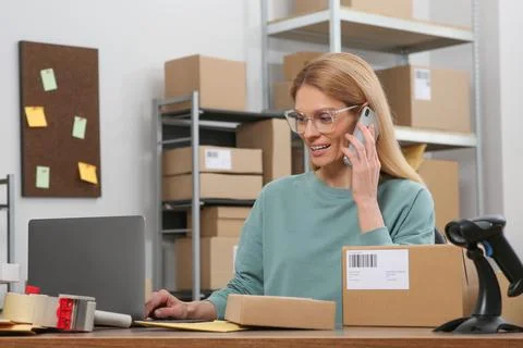 Seller talking on phone while working in office. Online store Photos