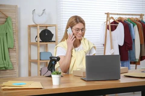Seller talking on phone while working in office. Online store Photos