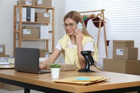 Seller talking on phone while working in office. Online store Photos