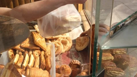 Selling fresh bread through bakery window. Customer pays banknote to baker and r Stock Footage 332876245