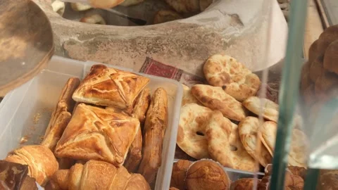 Selling hot bread. Baker sells hot traditional pita baked in stone tandoor. Roun Stock Footage 332876371