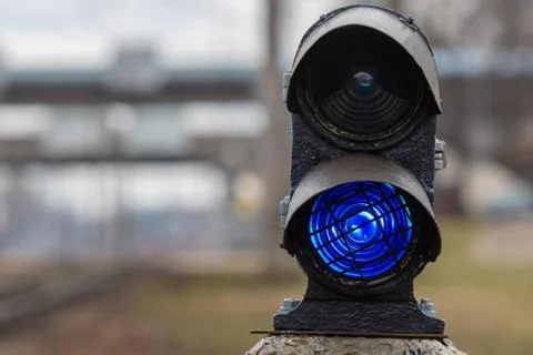 Semaphore with burning blue light. The intersection of railway tracks. - Imag Stock Photos