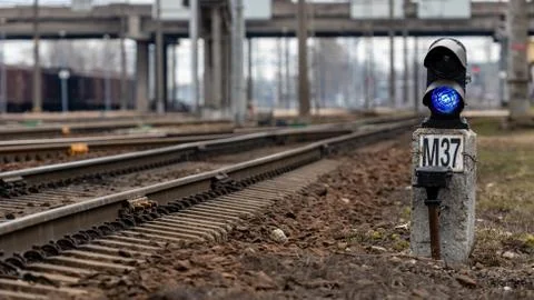 Semaphore with burning blue light. The intersection of railway tracks. - Imag Stock Photos